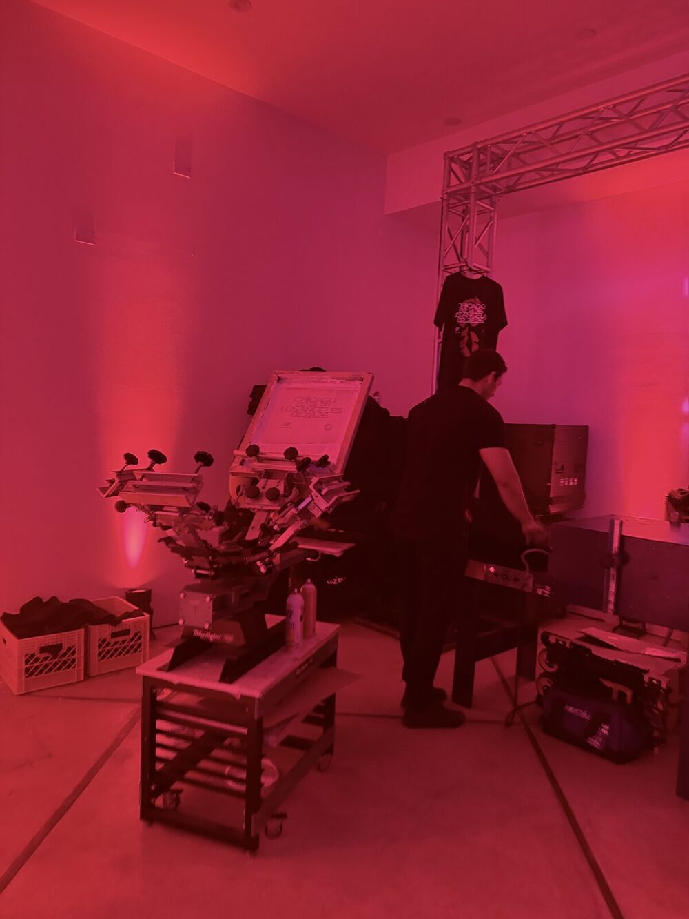 Crew setting up equipment under red uplighting before an evening event opens
