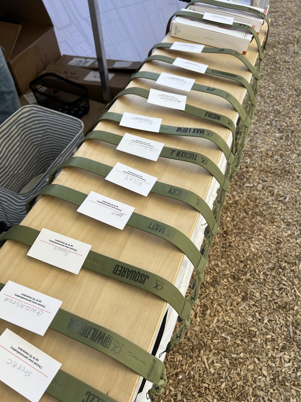 Long row of labeled personalization orders lined up on a table at an outdoor booth